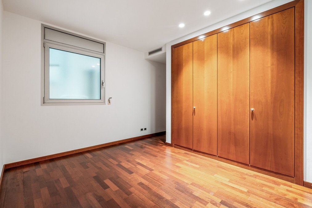 Dormitorio doble con armario empotrado de madera y suelo de parquet