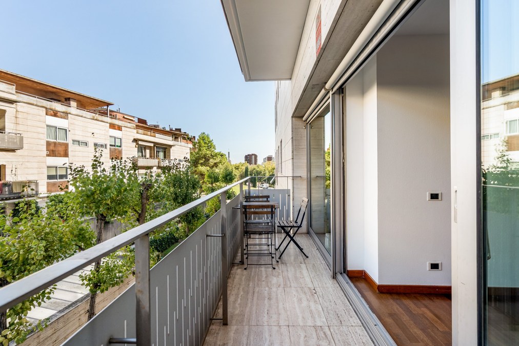 Terraza de unos 10 m² con mesa y sillas y vistas al patio ajardinado